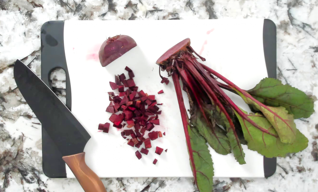 cut and chopped red beet on a cutting board with a knife