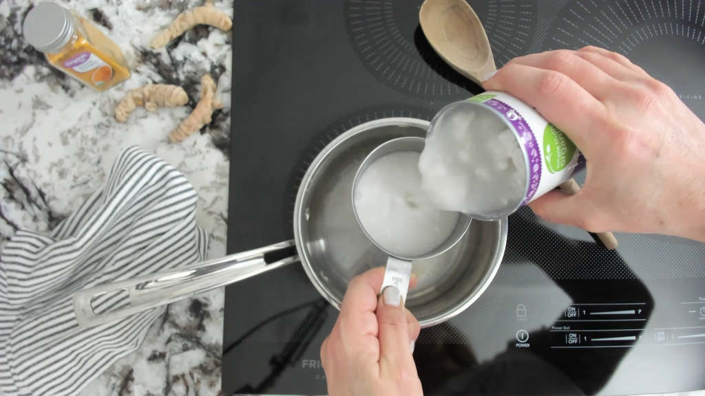 pouring coconut milk into a saucepan to make a turmeric milk golden latte