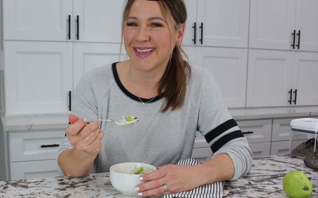 woman eating a winter pear and yogurt bowl breakfast